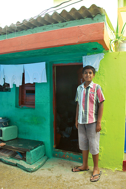 In a leper community, this Indian boy is proud of his newly repaired home.